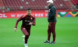 Robert Lewandowski, który ma najwięcej występów w reprezentacji Polski, podczas treningu. Obok niego stoi trener.