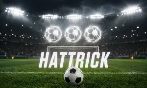 Piłkarski stadion nocą, trzy świecące piłki nad bramką i napis "HAT TRICK".