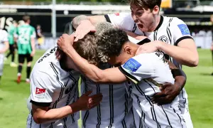 Piłkarze świętują zwycięstwo w barażach do Bundesligi. Radość i euforia po kluczowym meczu.