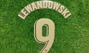 Numer 9 z nazwiskiem Lewandowski i logo Barcy na zielonej murawie.