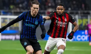 Piłkarze Interu i AC Milan, słynnego klubu piłkarskiego z Mediolanu, walczą o piłkę na boisku.