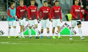 Młodzieżowa reprezentacja Polski w strojach meczowych na murawie.