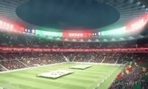 Widok na wypełniony po brzegi stadion, największy stadion na świecie, z flagami i tablicą wyników.