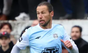 Piłkarz w jasnoniebieskiej koszulce z logo 4F i herbem klubu, gdzie gra Krychowiak, na tle kibiców.