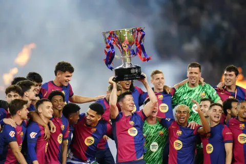 Piłkarze świętują zdobycie pucharu La Liga, wznosząc go nad głowami.