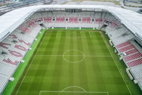 Stadion ŁKS z lotu ptaka, zielona murawa i puste trybuny. Jego pojemność pozwala na przyjęcie tysięcy kibiców.