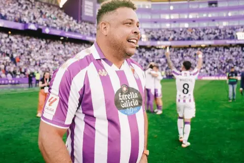 Ronaldo w koszulce Real Valladolid świętuje na boisku. Tłumy kibiców na trybunach.