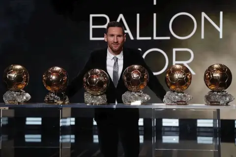 Lionel Messi stoi z siedmioma Złotymi Piłkami na tle napisu "BALLON D'OR".