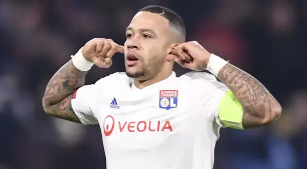 Memphis Depay w koszulce Olympique Lyon, z charakterystycznym gestem. Jego obecne drużyny to FC Barcelona i reprezentacja Holandii.