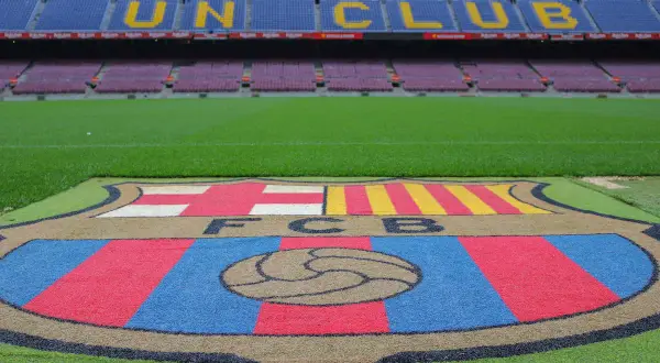 Herb FC Barcelony na murawie, gotowy na doping i przyśpiewki barcelony.