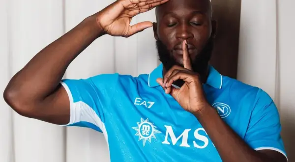 Piłkarz w niebieskiej koszulce Napoli, Romelu Lukaku, robi gest "cisza". Jego waga jest idealna do gry.