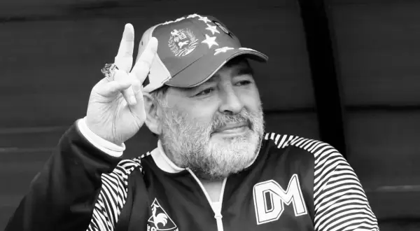Diego Maradona, w czapce z gwiazdami, pokazuje znak pokoju. Ile lat ma Maradona? To pytanie zadaje sobie wielu fanów.