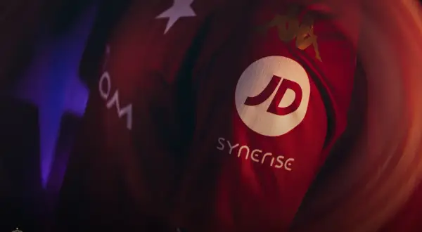 Czerwona koszulka Wisły Kraków z logo JD i Synerise. Widoczne też logo Kappa i gwiazda.