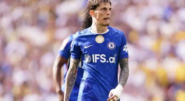 Piłkarz Chelsea w niebieskiej koszulce z logo IFS.ai, ich głównym sponsorze, podczas meczu.