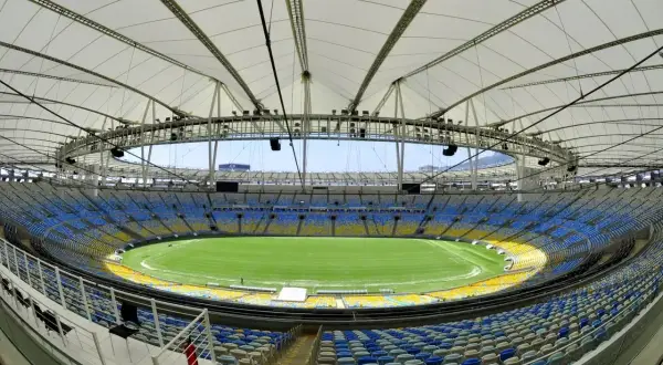 Pusta Maracana, z jej imponującą pojemnością, czeka na kibiców. Widok na zieloną murawę i żółto-niebieskie trybuny.