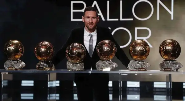 Lionel Messi stoi z siedmioma Złotymi Piłkami na tle napisu "BALLON D'OR".