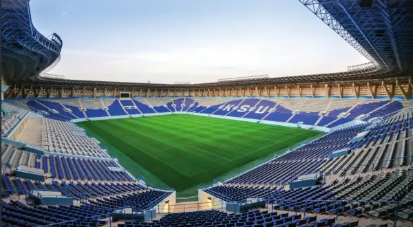 Puste trybuny stadionu Al Nassr czekają na kibiców. Zielona murawa lśni w słońcu, gotowa na emocjonujące mecze.