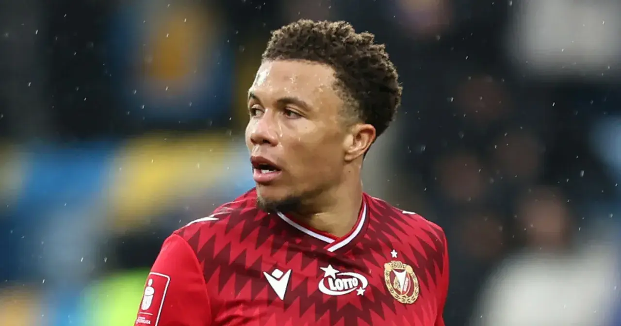 Piłkarz Rakowa Częstochowa w czerwonej koszulce z logo Lotto, gotowy do gry przeciwko Widzewowi Łódź.