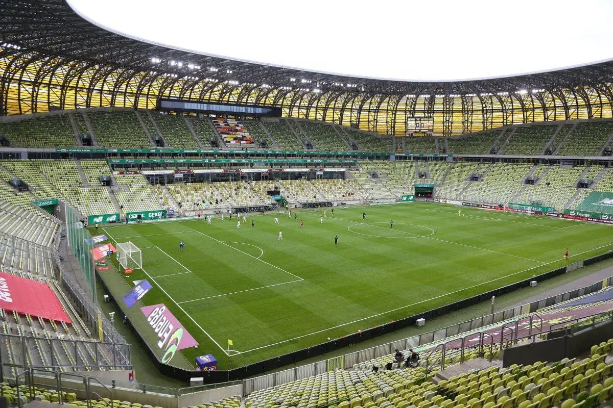Polsat Plus Arena Gdańsk, z zielonymi trybunami, gotowa na mecz. Jej pojemność pozwala na przyjęcie tysięcy kibiców.