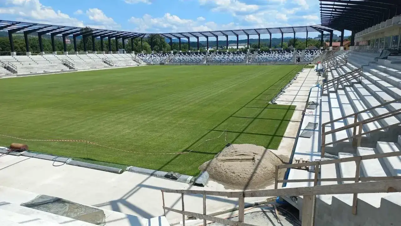 Nowy stadion Sandecji z zieloną murawą i betonowymi trybunami, gotowy na przyszłe mecze.