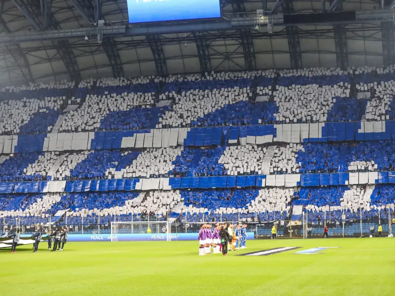 Tryumf w Lidze Europy! Trybuny stadionu wypełnione kibicami tworzącymi niebiesko-białą mozaikę.