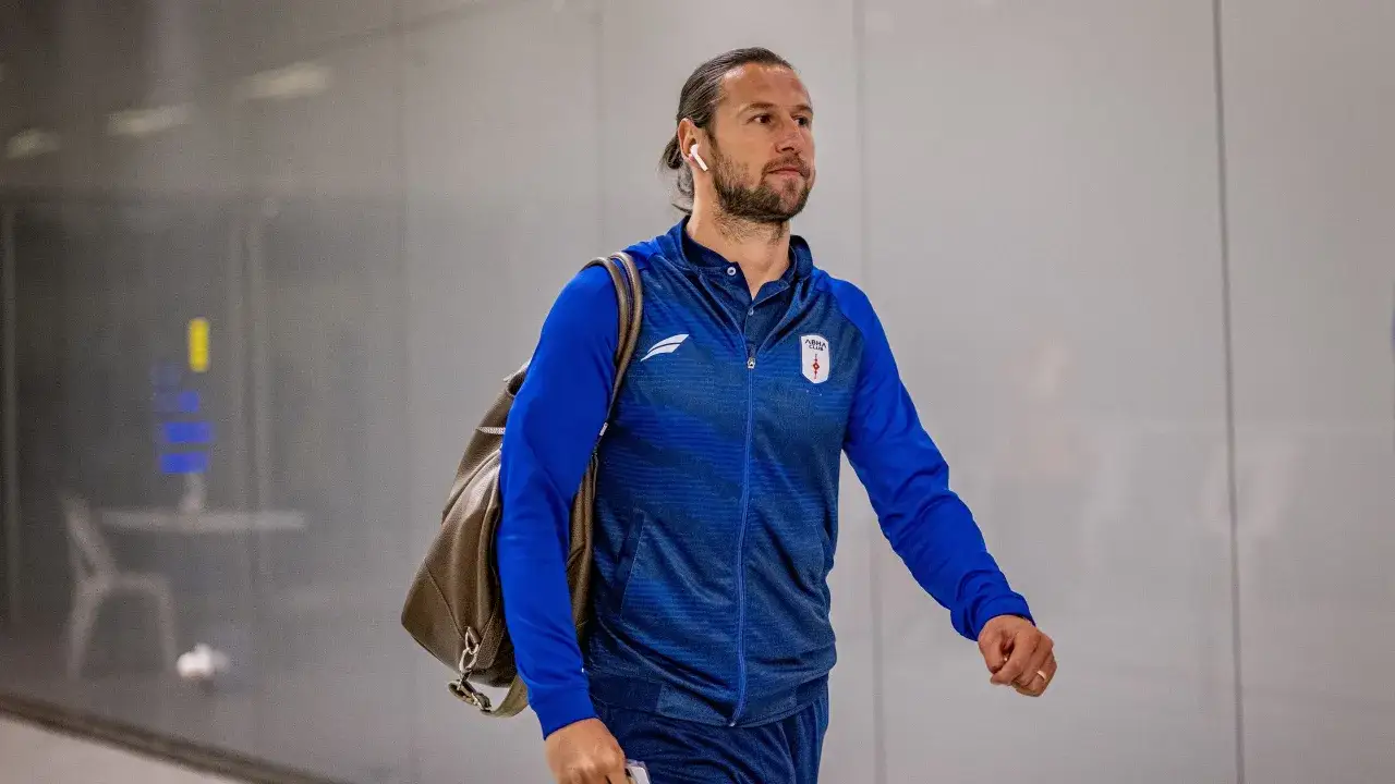 Grzegorz Krychowiak w drodze na mecz, w niebieskiej bluzie sportowej, z torbą na ramieniu.