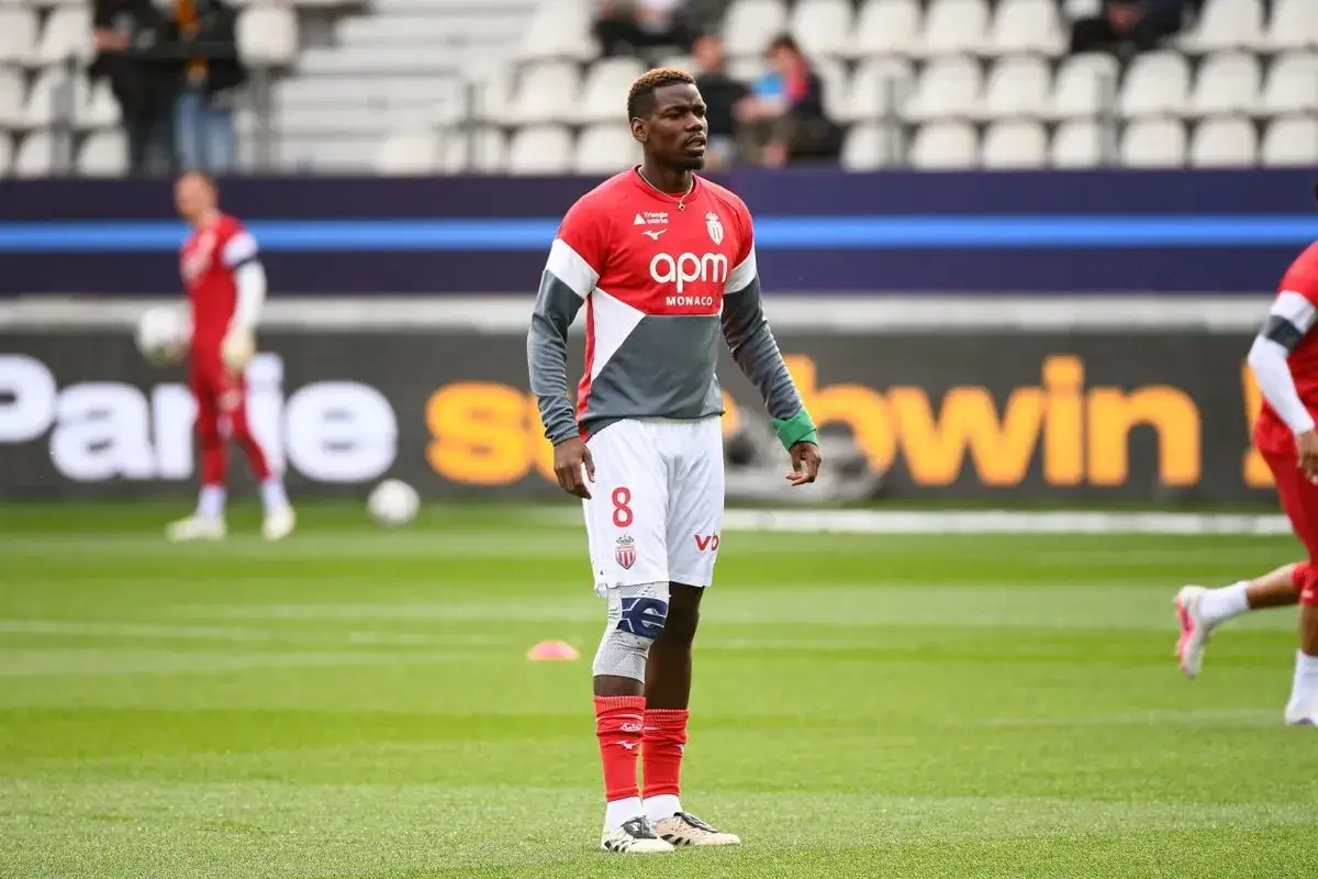 Piłkarz w czerwono-szarej koszulce z numerem 8, na boisku, gdzie gra Pogba.