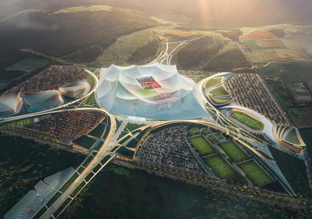 Futurystyczny kompleks sportowy z ogromnym, białym dachem nad boiskiem. Widać parkingi, boiska treningowe i inne budynki. To wizja największego stadionu na świecie.