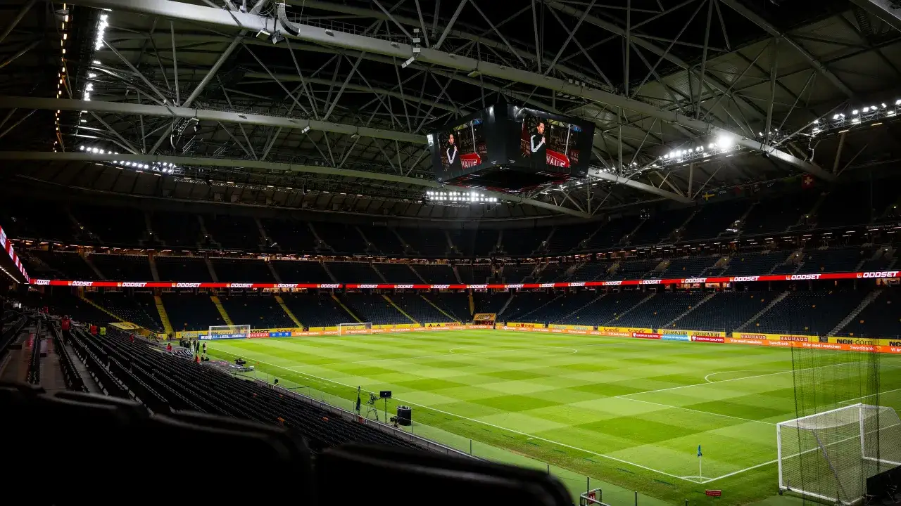 Pusta trybuny stadionu, zielona murawa i telebimy. Wygląda jakby mecz Polska-Szwecja unieważniony, bo nikogo nie ma.