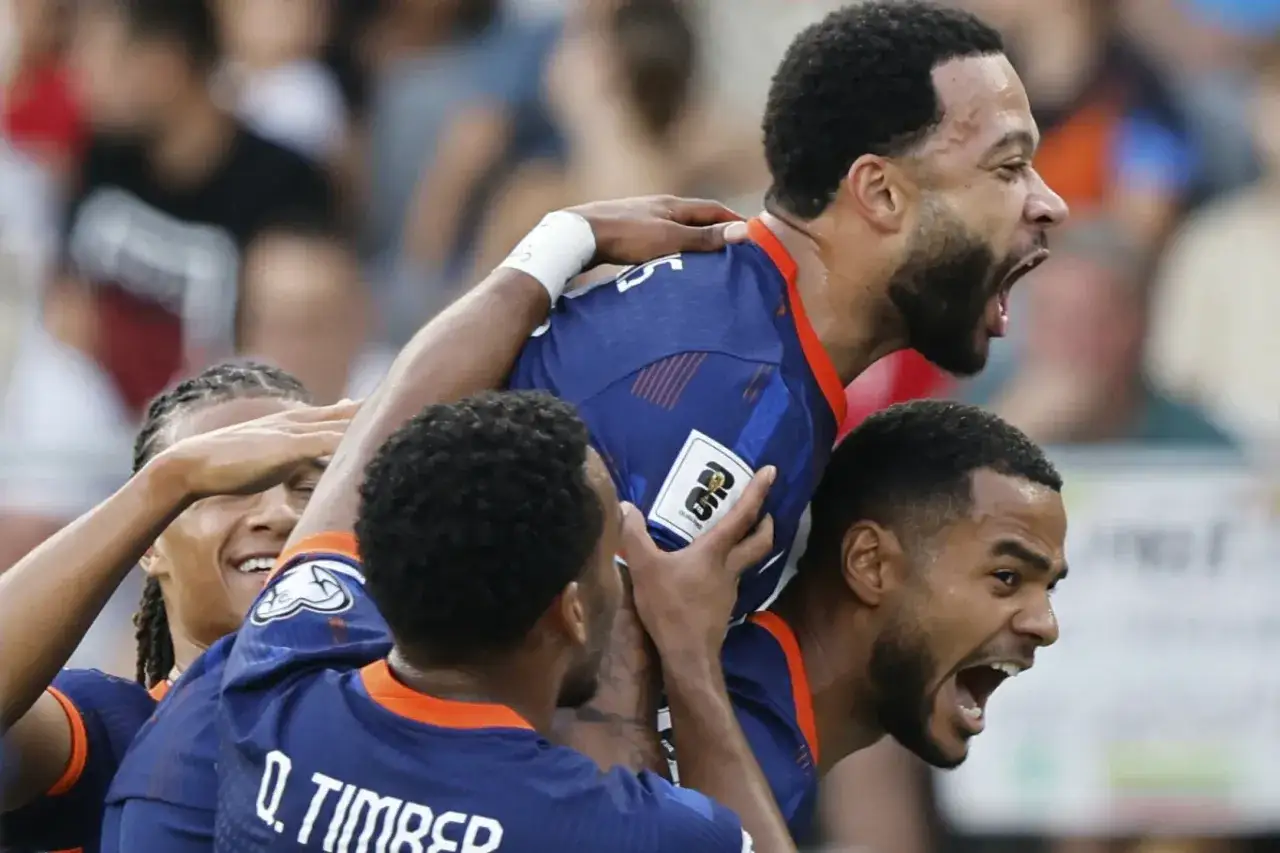 Piłkarze świętują bramkę. Memphis Depay, w środku, jest podnoszony przez kolegów z drużyny.