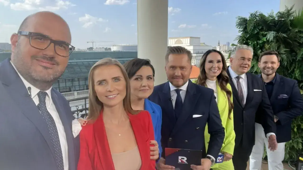 Grupa dziennikarzy i prezenterów TV Republika pozuje do zdjęcia na tle miasta.
