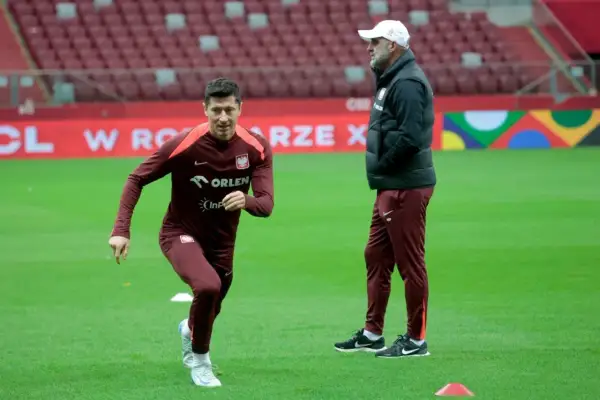 Robert Lewandowski, który ma najwięcej występów w reprezentacji Polski, podczas treningu. Obok niego stoi trener.