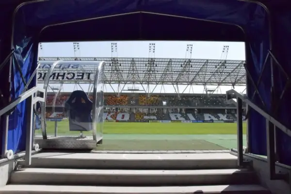 Widok z tunelu na murawę i trybuny stadionu miejskiego w Bielsku-Białej.