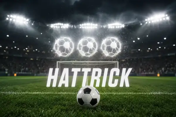 Piłkarski stadion nocą, trzy świecące piłki nad bramką i napis "HAT TRICK".
