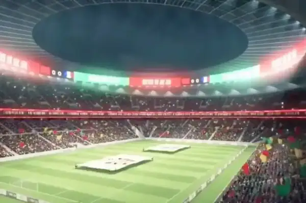 Widok na wypełniony po brzegi stadion, największy stadion na świecie, z flagami i tablicą wyników.