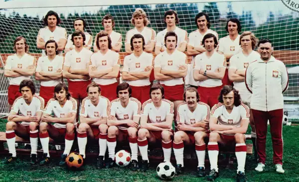 Reprezentacja Polski 1974 skład: piłkarze w białych koszulkach z orłem i czerwonych spodenkach pozują do zdjęcia przed bramką.